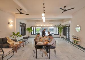 a group of people sitting at a table in a living room at Poshtel VNS in Varanasi