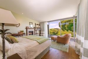 a bedroom with a bed and a large window at Waiheke Luxury Blue and Green Rooms in Ostend