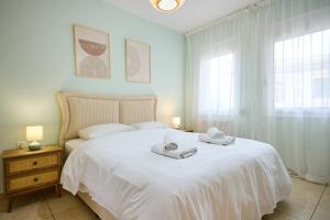 a bedroom with a white bed with towels on it at Bella Casa Chios in Chios
