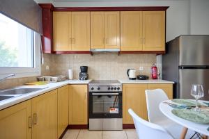 a kitchen with wooden cabinets and a sink and a table at Bella Casa Chios in Chios