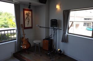 a recording room with a guitar and a camera at カルフールゲストハウス別館 in Toyama
