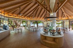 a large dining room with wooden ceilings and tables at PP Princess Resort in Phi Phi Islands