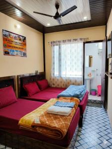 a bedroom with two beds and a couch at Trinetra Himalayan Stay in Phata