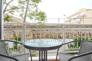 a glass table and chairs on a balcony at Bella Casa Chios in Chios