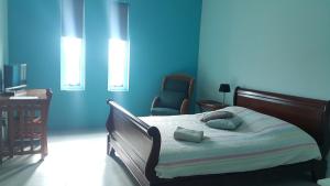 1 dormitorio con paredes azules y 1 cama con 2 almohadas en Guesthouse Curacao, en Willemstad