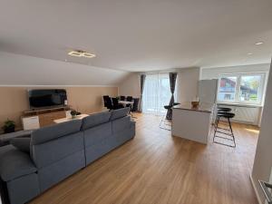 a living room with a gray couch and a kitchen at Toukam's Apartment, near Ingolstadt in Stammham