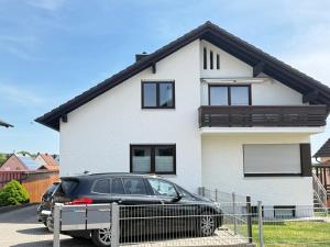 a black car parked in front of a white house at Toukam's Apartment, near Ingolstadt in Stammham
