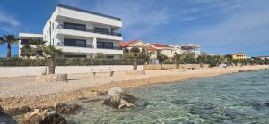 a building on the beach next to the water at Dinary Deluxe Apartments in Vir