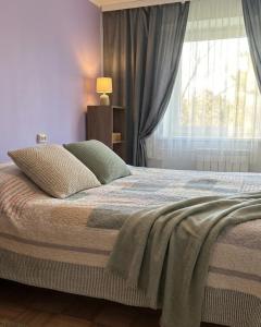 a bedroom with a large bed with a window at Vabaduse Apartment - külaliskorter Kärdlas in Kärdla