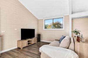 a living room with a couch and a flat screen tv at Bilpin Station in Bilpin