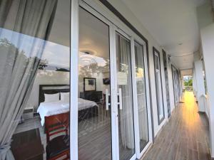 a bedroom with sliding glass doors and a bed at Kampot Origin in Kampot