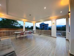 a large living room with a table and chairs on a balcony at Kampot Origin in Kampot