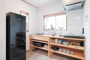 a kitchen with a counter with a sink and a refrigerator at rinne 伊豆 Private Spa in Ito