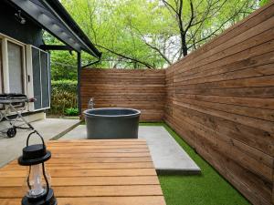 a wooden fence with a bath tub in a yard at rinne 伊豆 Private Spa in Ito