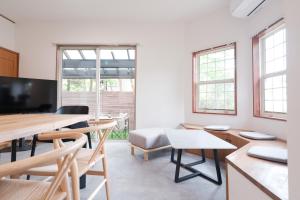 a living room with a table and chairs and a television at rinne 伊豆 Private Spa in Ito +37 photos