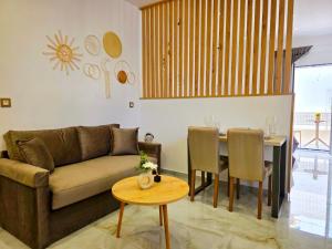 a living room with a couch and a table at Anthouli homes 4, steps from beach and centre in Kardamaina