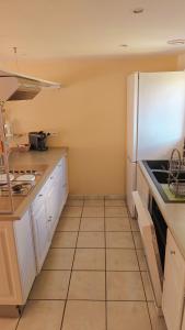 a kitchen with white cabinets and a white refrigerator at L'orée du vignoble in Vaux-en-Beaujolais +6 photos
