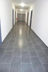 an empty hallway of an office with a tile floor at Budget Hotel Ludwigshafen in Ludwigshafen am Rhein
