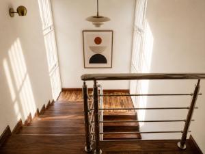a staircase with a metal rail in a room with windows at Residencial Rochili in Chimoio