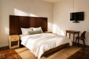 a bedroom with a bed and a tv on the wall at Residencial Rochili in Chimoio