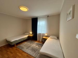 a small room with two beds and a window at Villa Lindäng Apartment -Vimmerby in Vimmerby