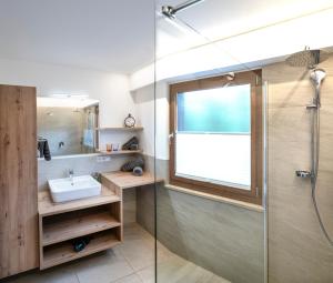 a bathroom with a glass shower and a sink at Apartments Sayonara in Castelrotto +54 photos