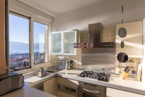 a kitchen with a sink and a large window at Apartment Arcadia in Rijeka