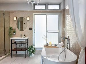 a bathroom with a tub and a sink at Common Living Iconsiam in Bangkok +71 photos