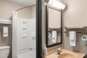 a bathroom with a sink and a shower with a mirror at Super 8 by Wyndham Kalispell Glacier National Park in Kalispell +31 photos