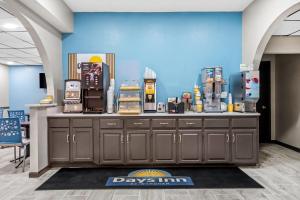 a store counter with machines on a blue wall at Days Inn by Wyndham Troy in Troy