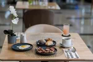 a table with two plates of food and a cup of coffee at Ramada by Wyndham Manila Central in Manila