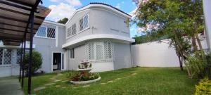 a white house with a fence and a yard at Hotel Urban Home in Guatemala