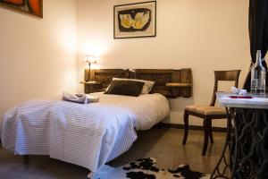 ガヴィラーテにあるCorte dei Brutのベッドルーム1室(ベッド1台、テーブル、椅子付)