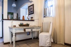 um quarto com uma mesa branca e uma cadeira em Corte dei Brut em Gavirate