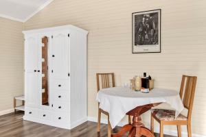 a dining room with a table and a cabinet at Bilpin Station in Bilpin