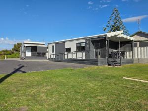 a building with a grassy yard in front of it at Kingston Foreshore Caravan Park in Kingston South East