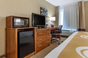 a hotel room with a bed and a television and a desk at Quality Inn Dover in Dover