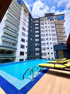 a swimming pool with yellow umbrellas and some buildings at Mira Heights Suites & Conferencing Mombasa in Mombasa