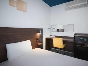 a bedroom with a bed and a desk and a yellow chair at Comfort Hotel Wakayama in Wakayama +27 photos