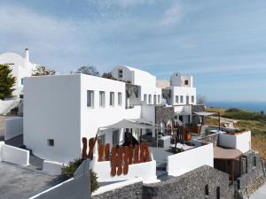 a view of a white building with chairs at Lumera Suites in Firostefani