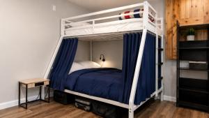 a bedroom with a bunk bed with blue sheets at Tuscan Ridge Guesthouse Calgary West in Calgary