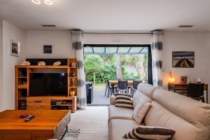 a living room with a couch and a television at Le Reve Mimizan Plage in Mimizan-Plage