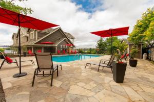 a patio with chairs and umbrellas next to a pool at Rawley Resort, Spa & Marina, Trademark Collection by Wyndham in Port Severn