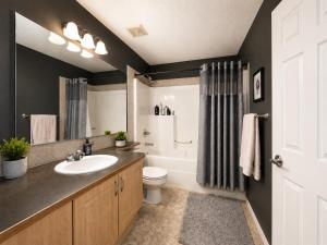 a bathroom with a sink and a toilet and a tub at Tuscan Ridge Guesthouse Calgary West in Calgary
