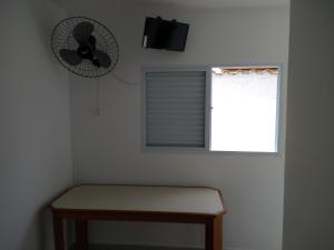 a room with a fan and a bench and a window at Consulado Praia Hotel in Guarujá