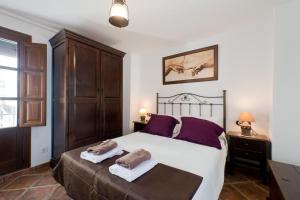 1 dormitorio con 1 cama grande y 2 toallas en Casita del Realejo, en Granada