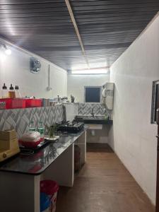 a kitchen with a long counter in a room at The Tea Tribe Stay in Sonāda