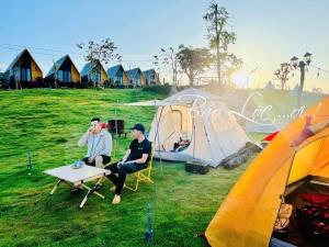 two men sitting at a table in front of tents at Lang Omm in Tang Klang