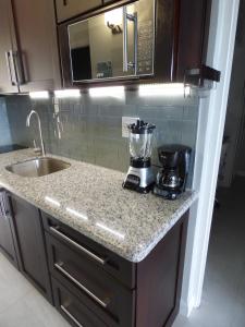 a kitchen counter with a blender and a sink at Beach Two Bedroom Loft Suite E29 in Ocho Rios