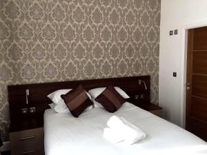 a bedroom with a bed with brown and white pillows at Marlborough Hotel in Liverpool